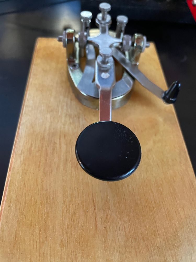 A freshly cleaned JJ-38 replica straight key on a light wood base