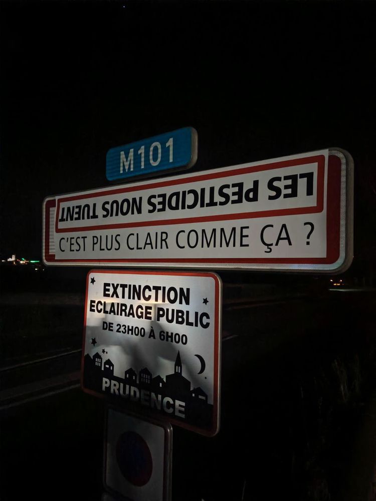 panneau à l'entrée d'un village : "les pesticides nous tuent, c'est plus clair comme ça ?"