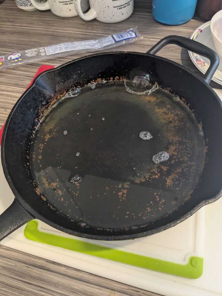 A cast iron pan full of bubbly water… and rust.