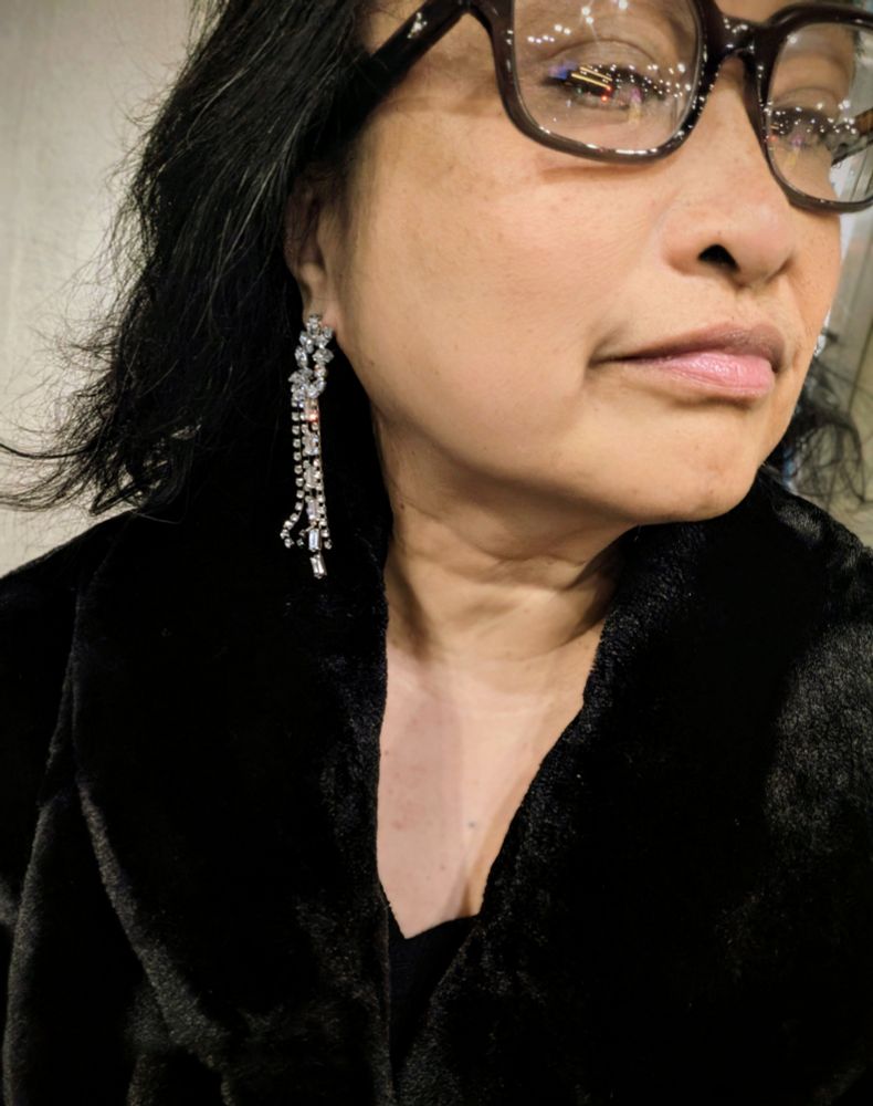 Me wearing glittery dangly earrings, fur coat, glasses & an imperious look.