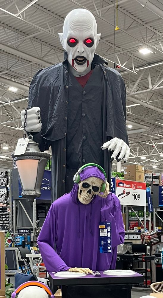 Halloween animatronics at Lowe’s: a skeleton DJ in a purple hooded robe and a 12 ft tall vampire with black lips and glowing red eyes