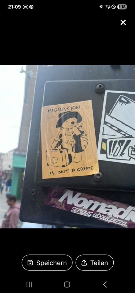 Ein Sticker in beiger Farbe mit Paddington Bär der einen Koffer hält.
"Migration is not a crime".