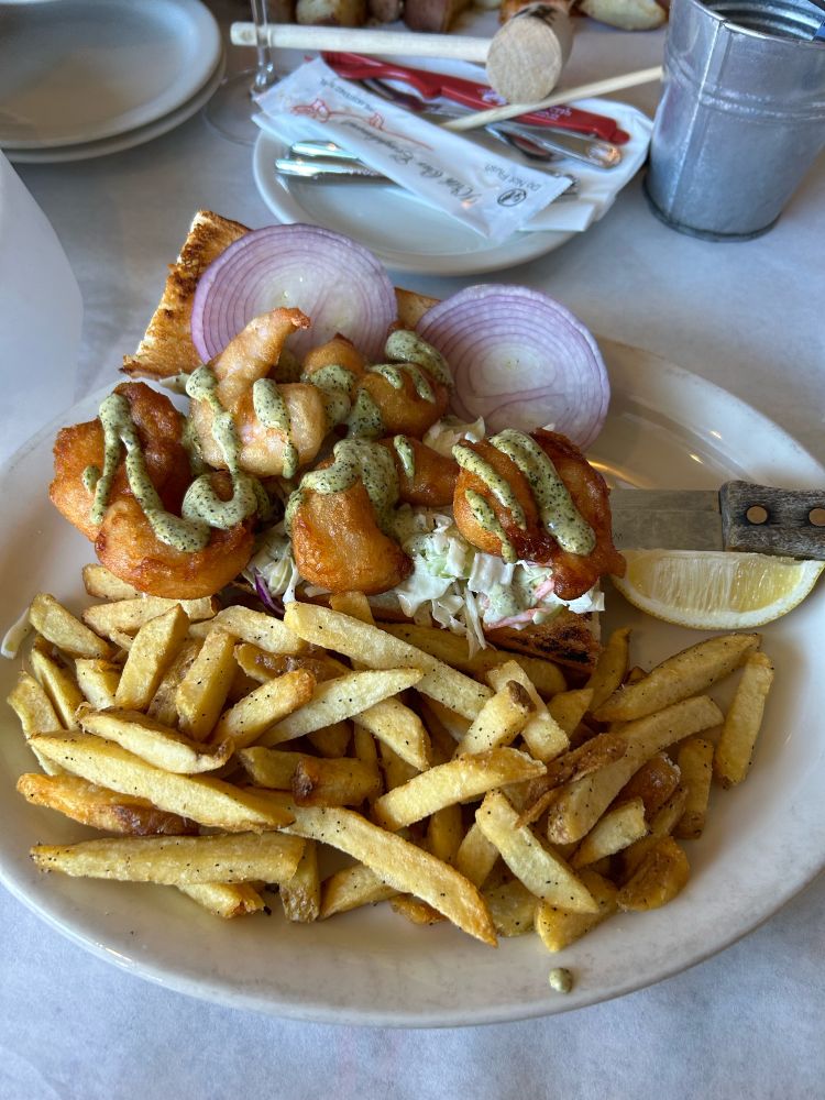 A Shrimp Po Boy sandwich with a side of french fries