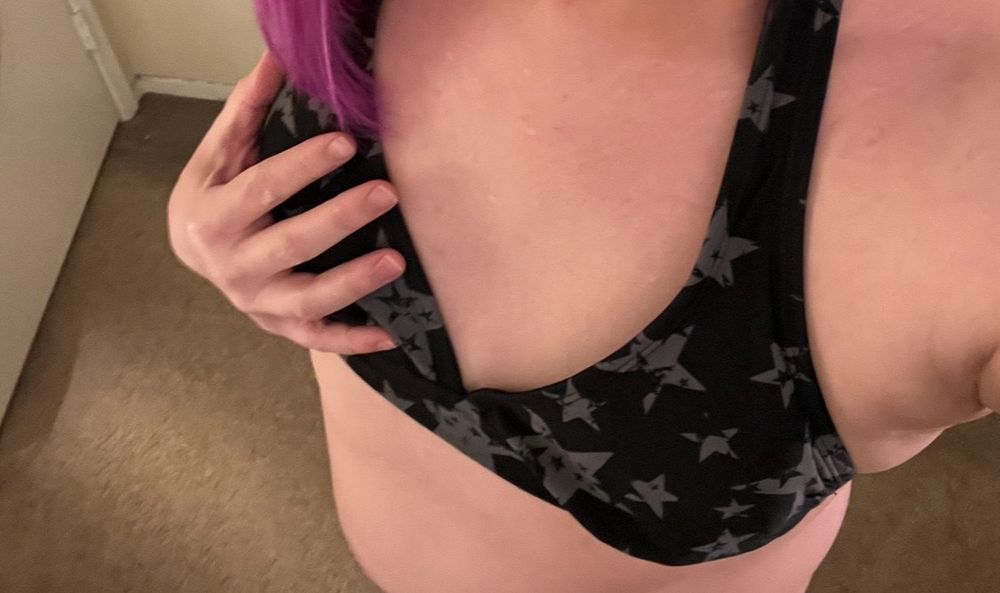Her hand is grabbing her boob in a black and gray star top