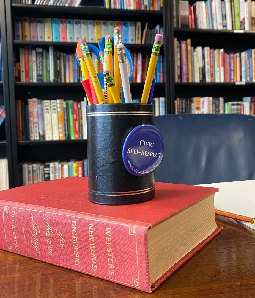 A picture of Ralph Nader's desk featuring a pencil holder and a button that reads "Civic Self-Respect".