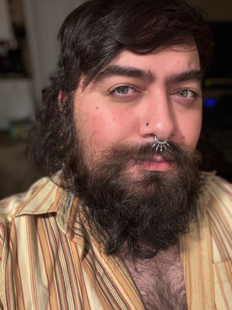 Selfie smiling with a big bush beard. Shirt unbuttoned to show a bit of my hairy chest