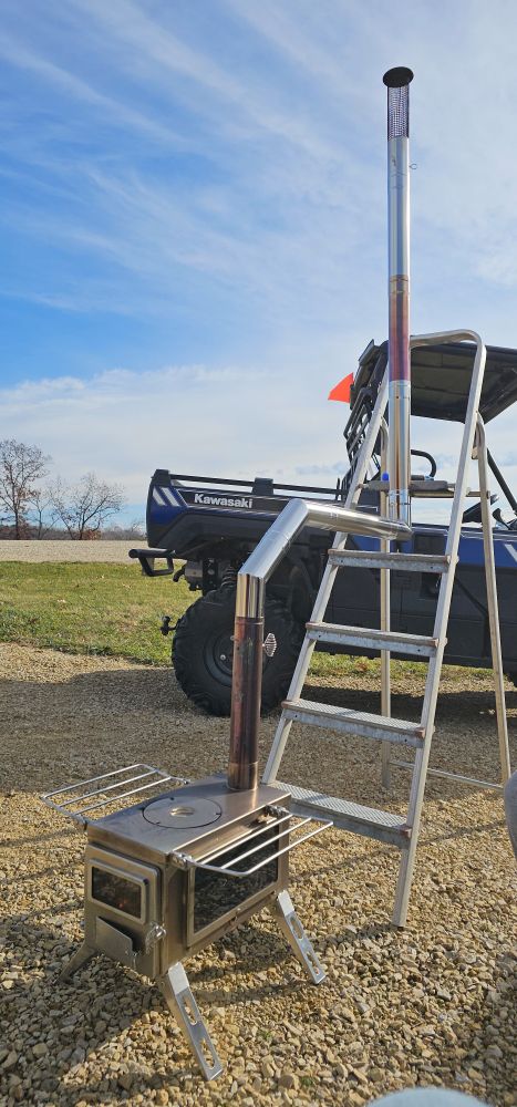 Showing a medium size winnerwell wood stove, with a chimney curving from vertical to horizontal back to vertical.

Had sone trouble getting it started,  but now it seems to be working
