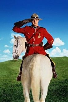 Publicity photo for the movie DUDLEY DO-RIGHT showing Brendan Fraser as the main character sitting backwards on a white horse. He is wearing a Mountie uniform and hat, and is saluting.