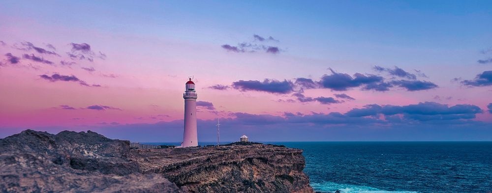 Lighthouse on a cliff at sunset 