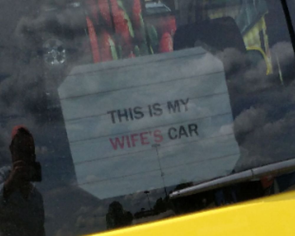 Closeup of the sign, stating "this is my WIFE'S" car