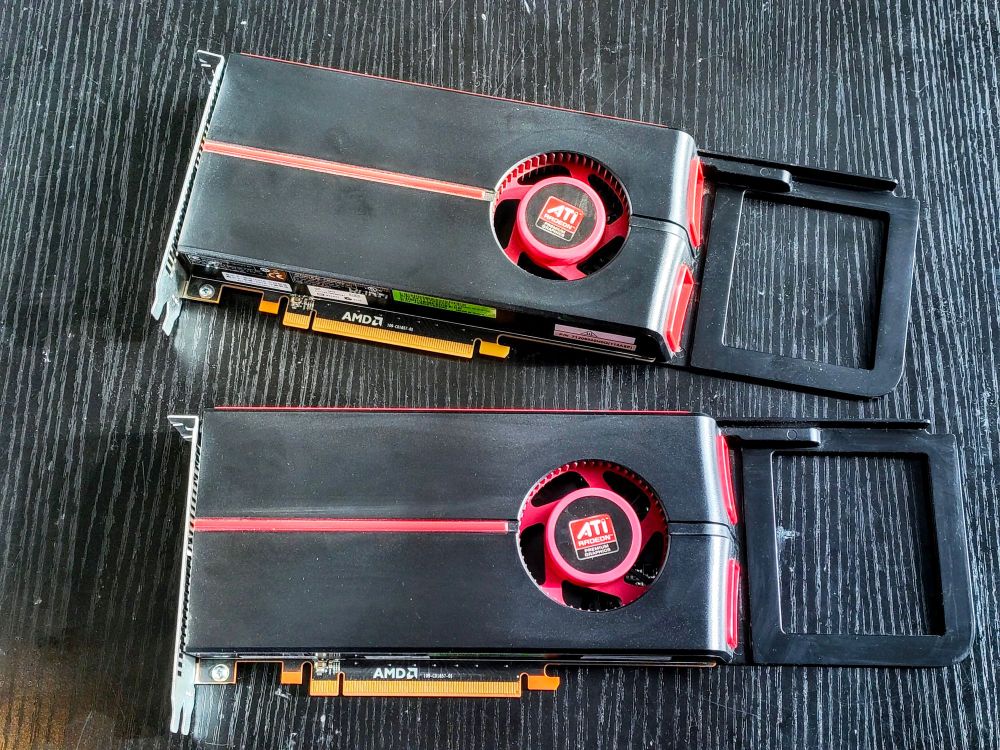 a pair of ATI Radeon 5770 graphics cards fearing the classic red on black "racing stripe" blower / turbo coolers