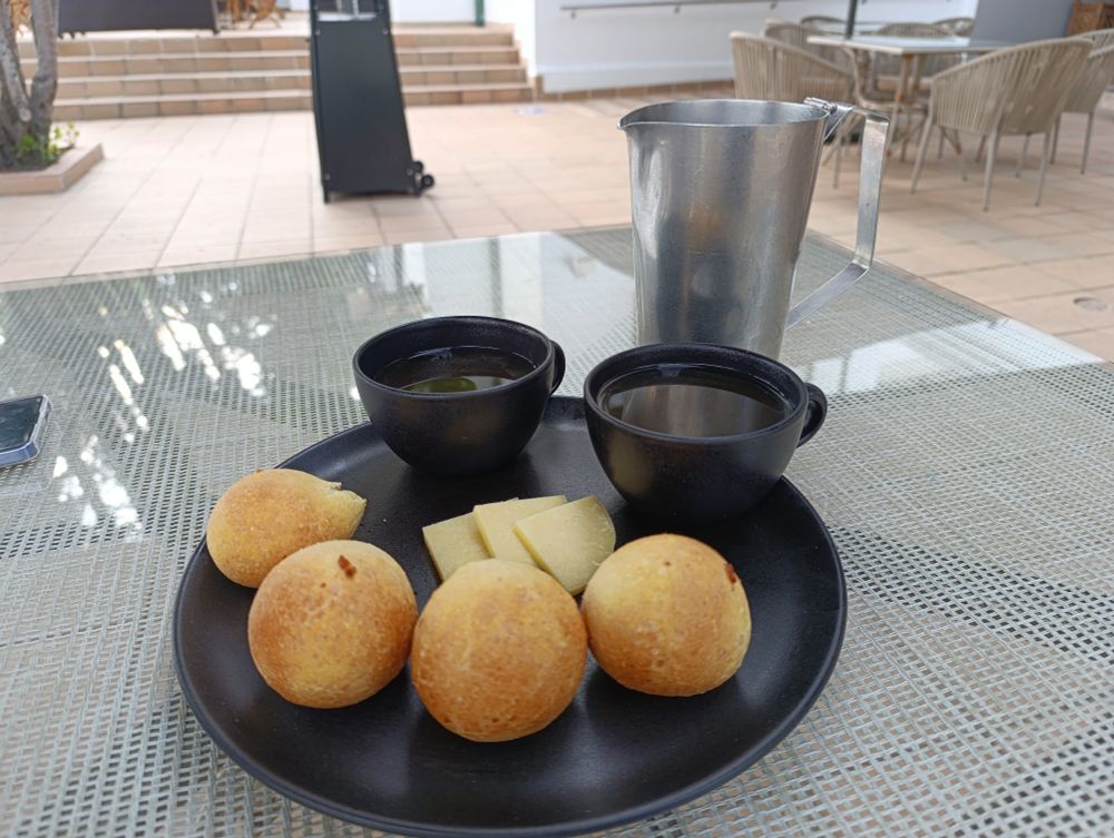 A plate with almojabanas and agua de panela.