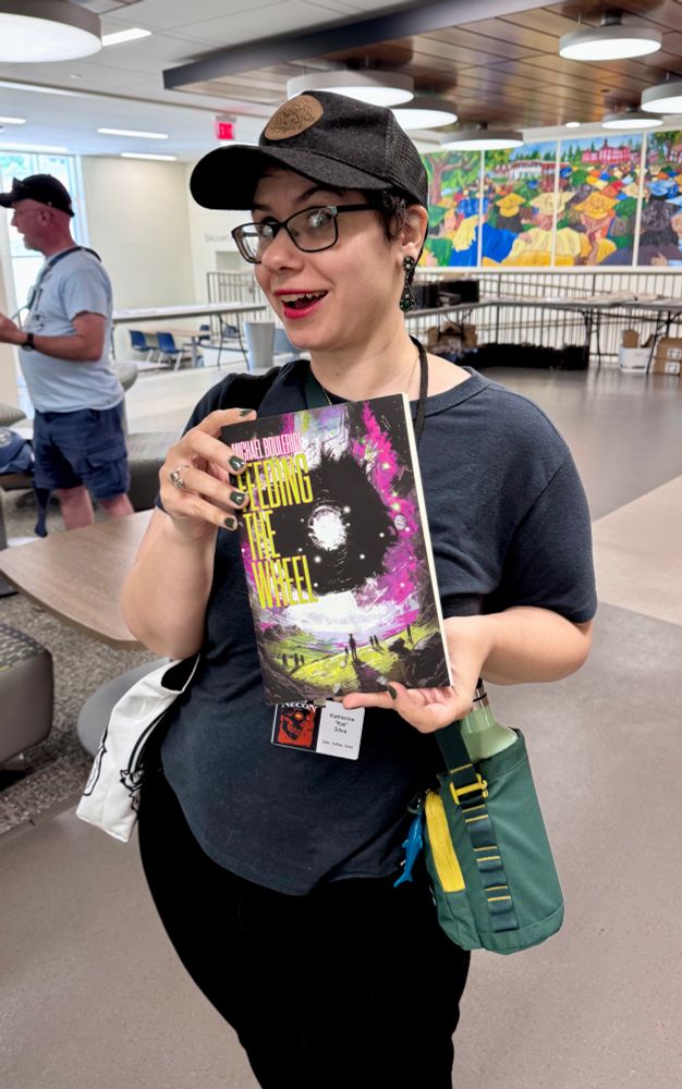 Katherine "Kat" Silva holding up a copy of Feeding the Wheel in the Necon lobby. Kat is the friggin best. If you're at Necon this weekend make sure you say hi 