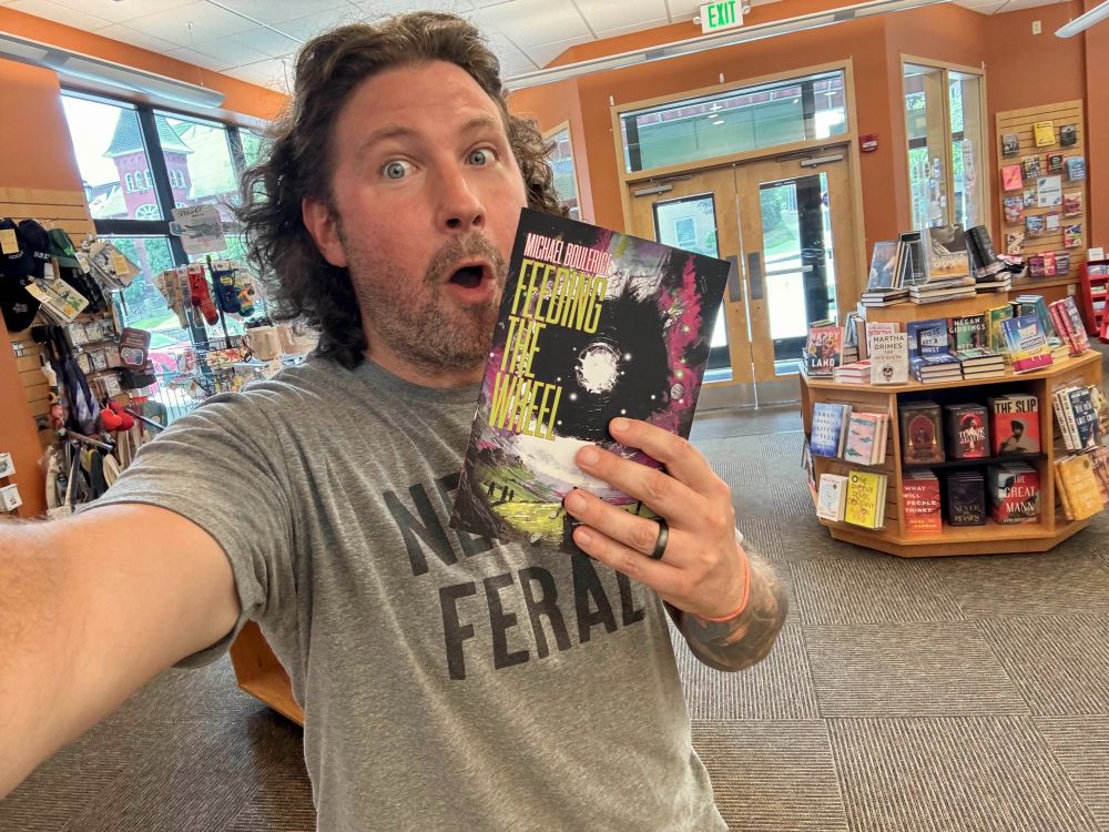 A very very very very excited Michael Boulerice holding up a copy of Feeding the Wheel inside Gibson's Bookstore in Concord, New Hampshire. 