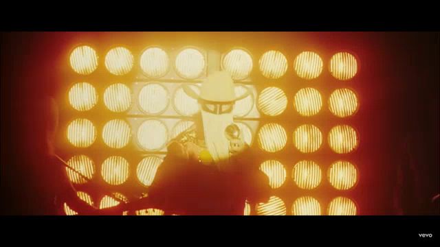 a man in a cowboy hat is playing a guitar in front of a wall of lights