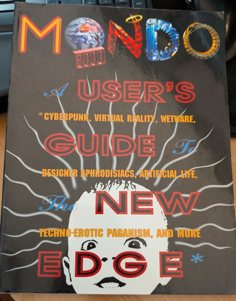 A much higher resolution picture of Mondo 2000's "A User's Guide to the New Edge" specifying "cyberpunk, virtual reality, wetware, designer aphrodisiacs, artificial life, techno-erotic paganism, and more"
