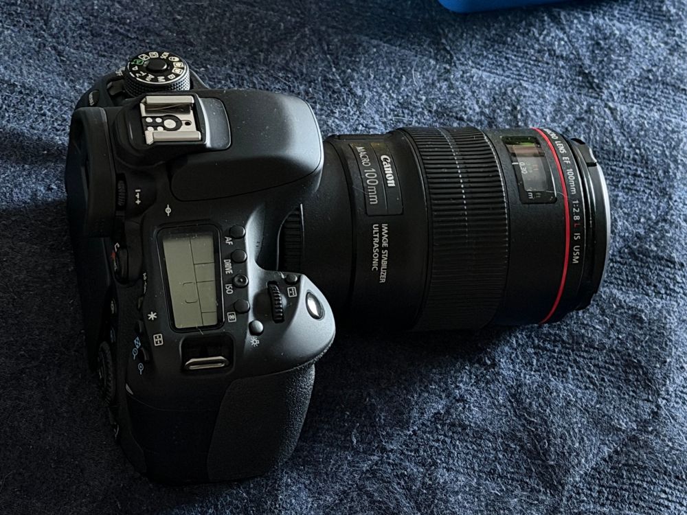 Photo of my DSLR camera with a telephoto lens attached. It’s black with lots of buttons