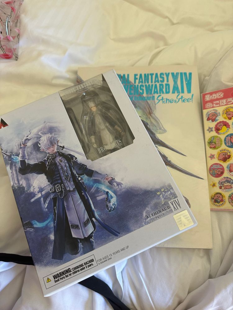 Figure of Alphinaud in his Endwalker outfit (boxed), the first Heavensward art book, and also some Kirby stickers.