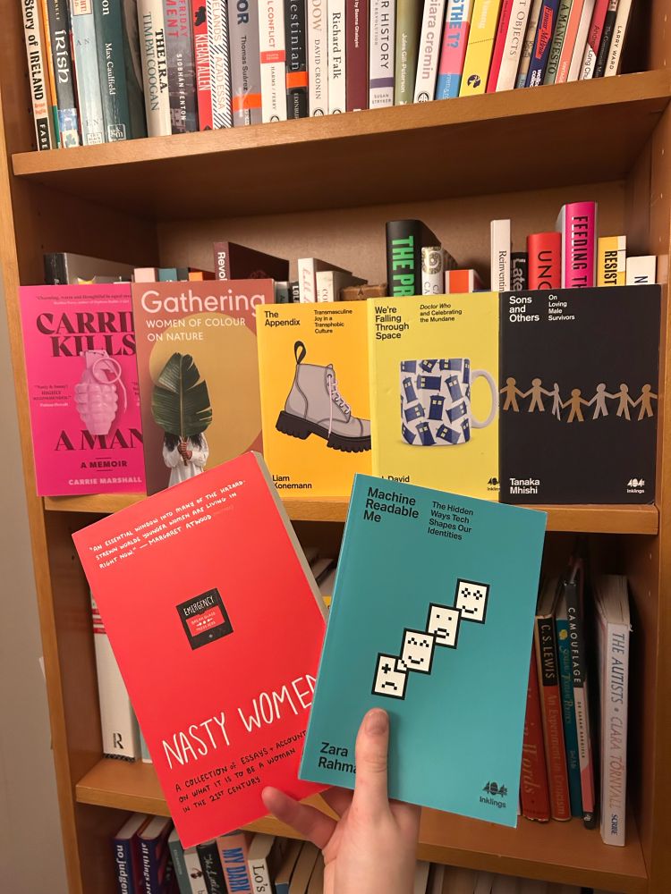 the user’s hand is holding a copy of Zara Rahman’s Machine Readable Me and the collection of essays named Nasty Women. in the background are other books by the same publisher: Carrie Kills a Man, Gathering, The Appendix, We’re Falling Through Space, and Sons and Others