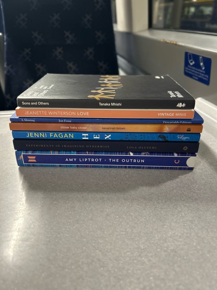 a stack of books: Tanaka Mhishi’s Sons and Others, Jeanette Winterson’s Love, Jon Fosse’s A Shining, Savannah Brown’s Closer Baby Closer, Jenni Fagan’s Hex, Lola Olufemi’s Experiments in Imagining Otherwise, and Amy Liptrot’s The Outrun