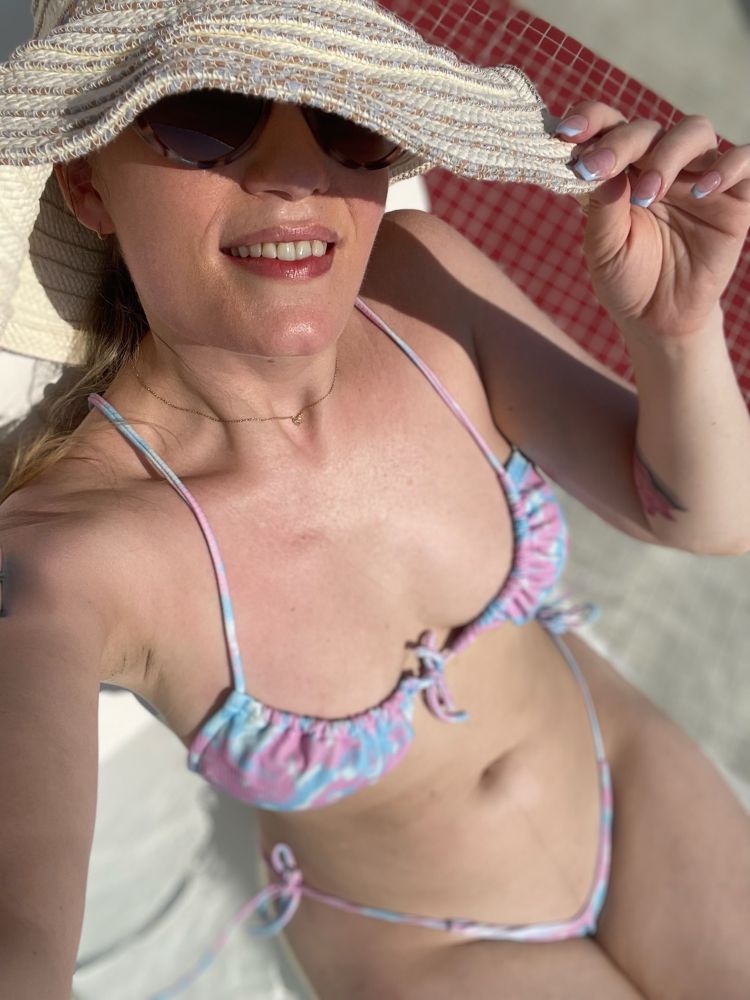Madeline wears a teeny bikini and lounges in the shallow end of the pool