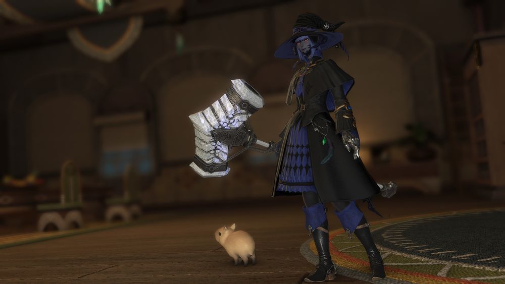 Solazz stands in a turali inn room wearing black and blue robes and witch hat with a large, bone like hammer in hand

a capybara pup stands to the side