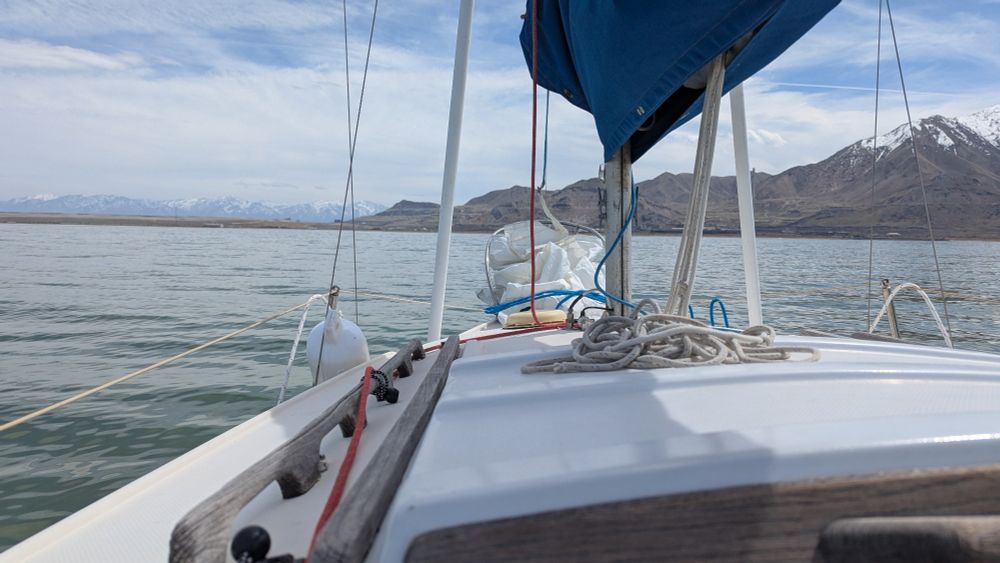 A sailboat with sails dropped. Lines run across the deck ready to raise the sails 