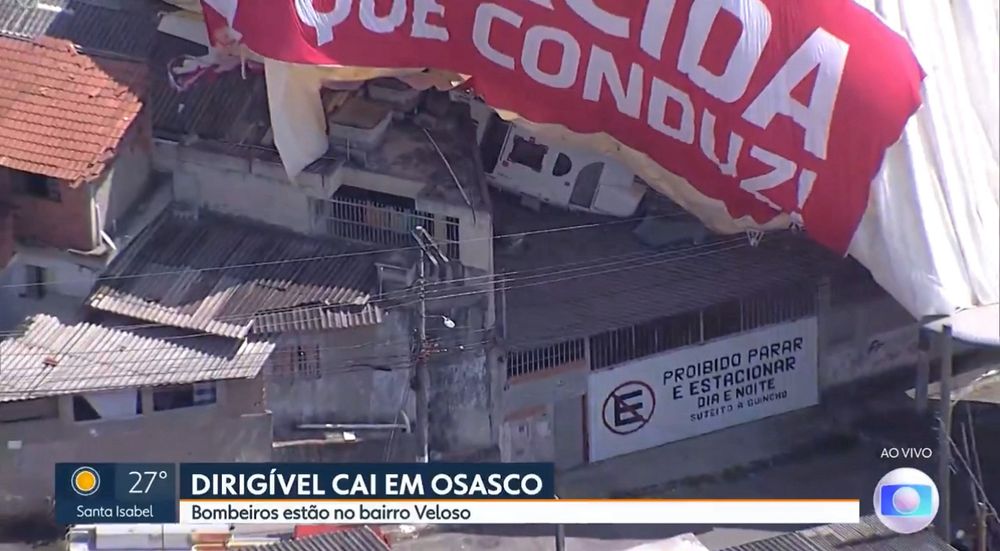 Dirigível todo flácido sobre uma casa com o aviso Proibido Estacionar no portão.