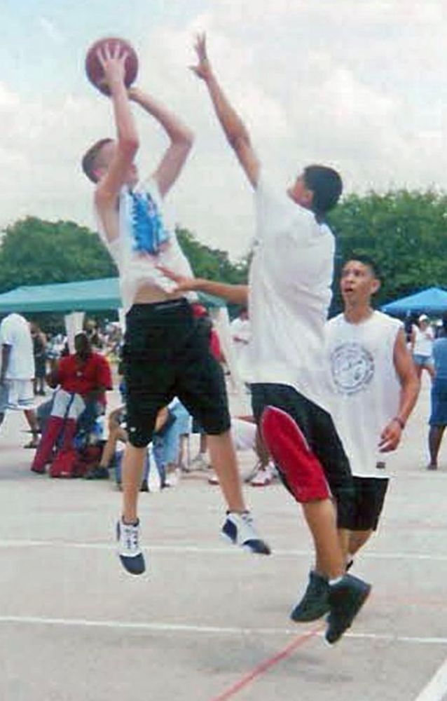 A much younger me shooting a fadeaway during an outdoor basketball game