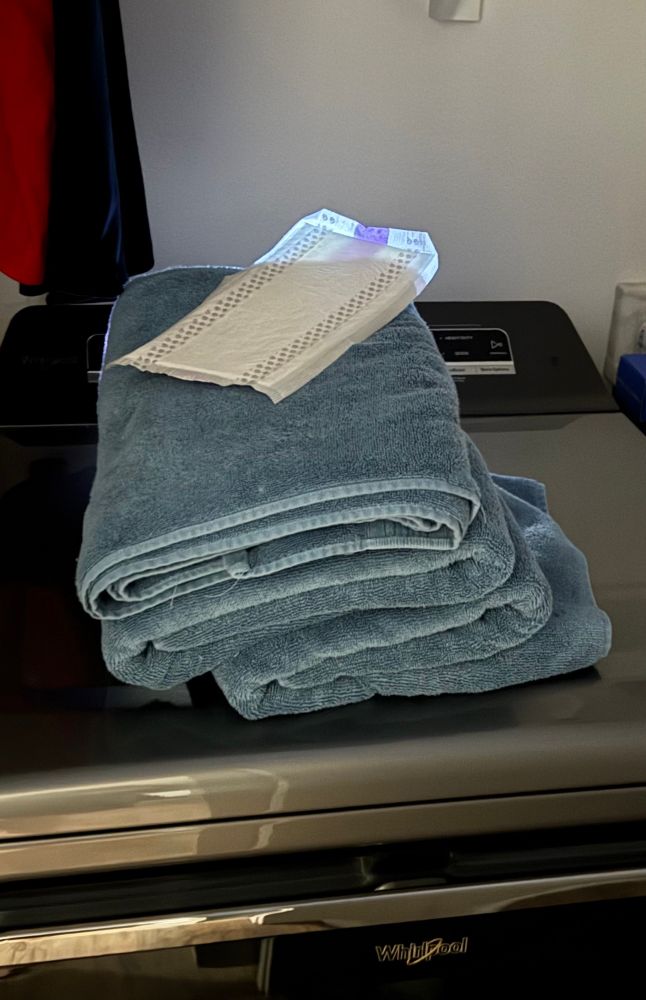 A lone Swiffer pad sitting atop a couple of folded blue towels with an ominous glow