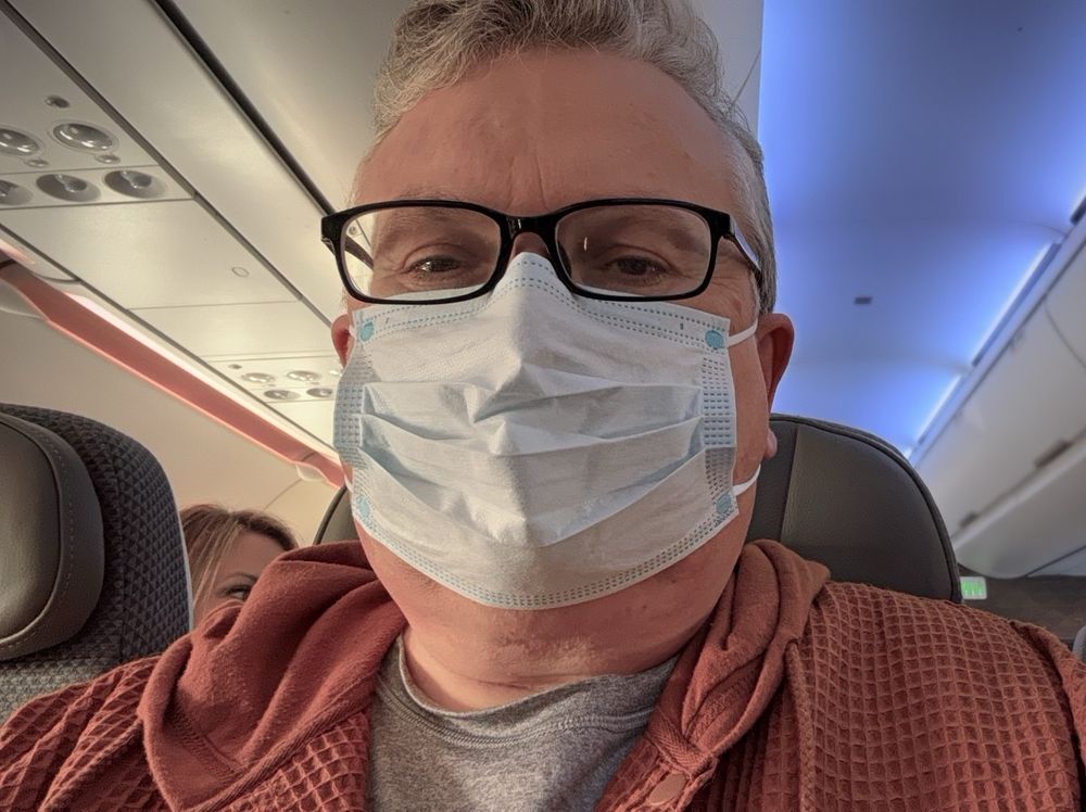 Our brave hero wears a mask on his flight to Hawaii. 
