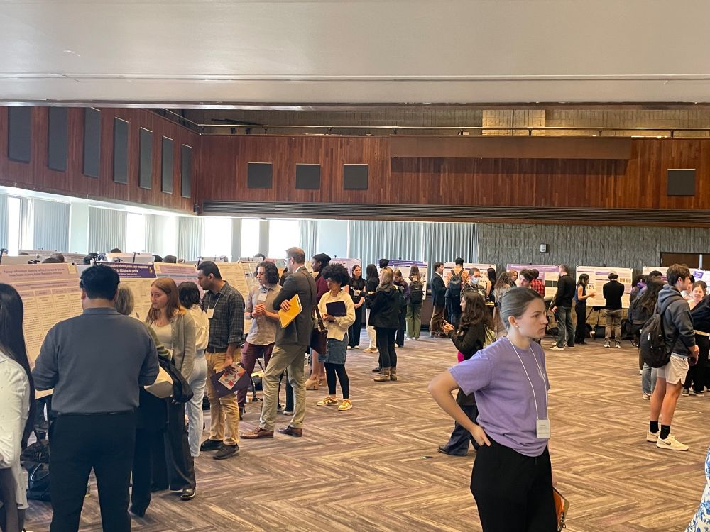 Landscape photo of northwestern research expo, with research posters lined up and lots of students presenting and talking to judges. 