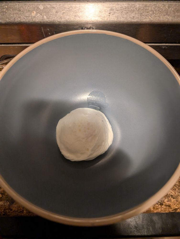 A very aesthetically pleasing, almost perfectly twirled poached egg sitting in the bottom of a slate blue bowl