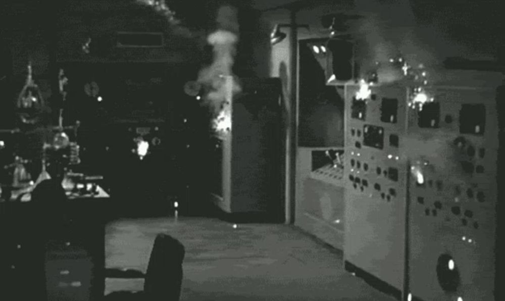 a black and white photo of a room with a lot of electrical equipment and smoke coming out of it .