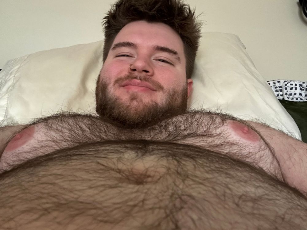 Selfie from below my belly looking up, showing my stomach and chest, I’m smiling hehe