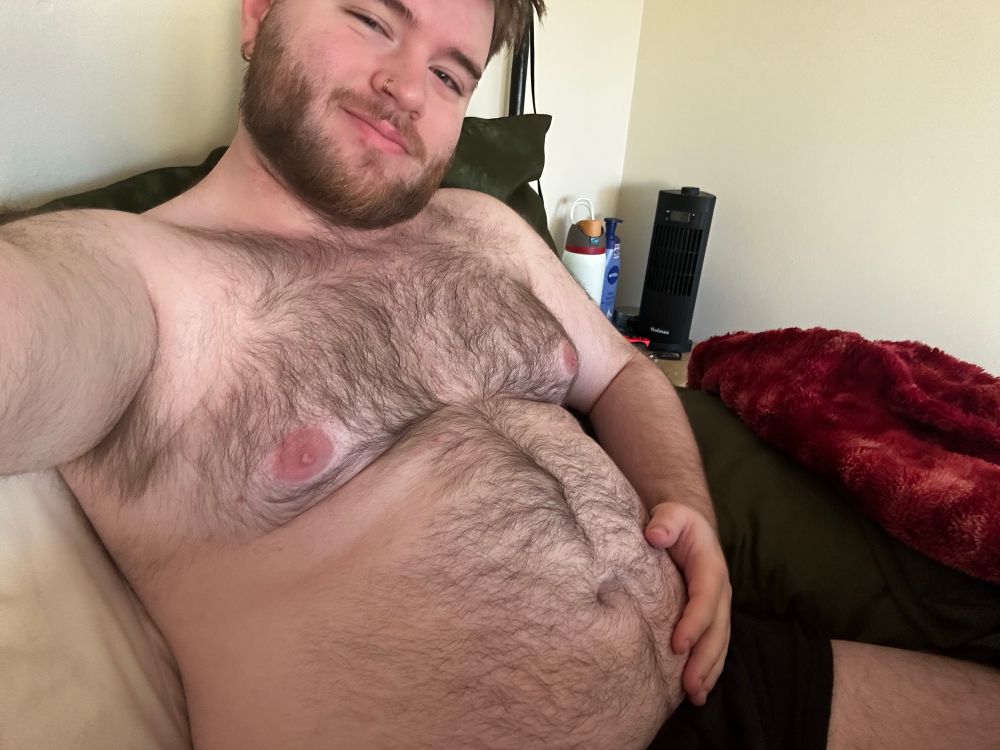Selfie of me in bed in just my black boxer briefs, hand on my belly, I was so full from the night before lol