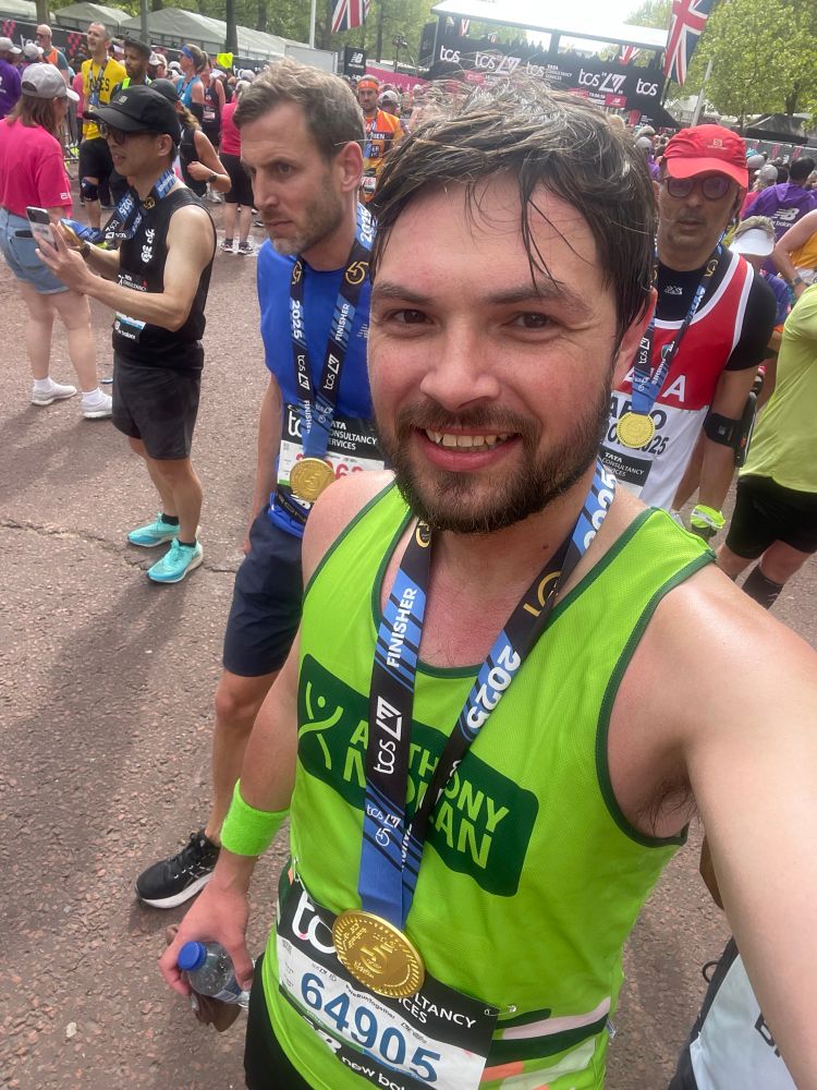 Chris with medal at the finish line (after his legs had started working again)