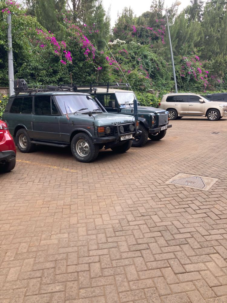 Green Land Rover Defender parked next to a metallic grey Range Rover Classic