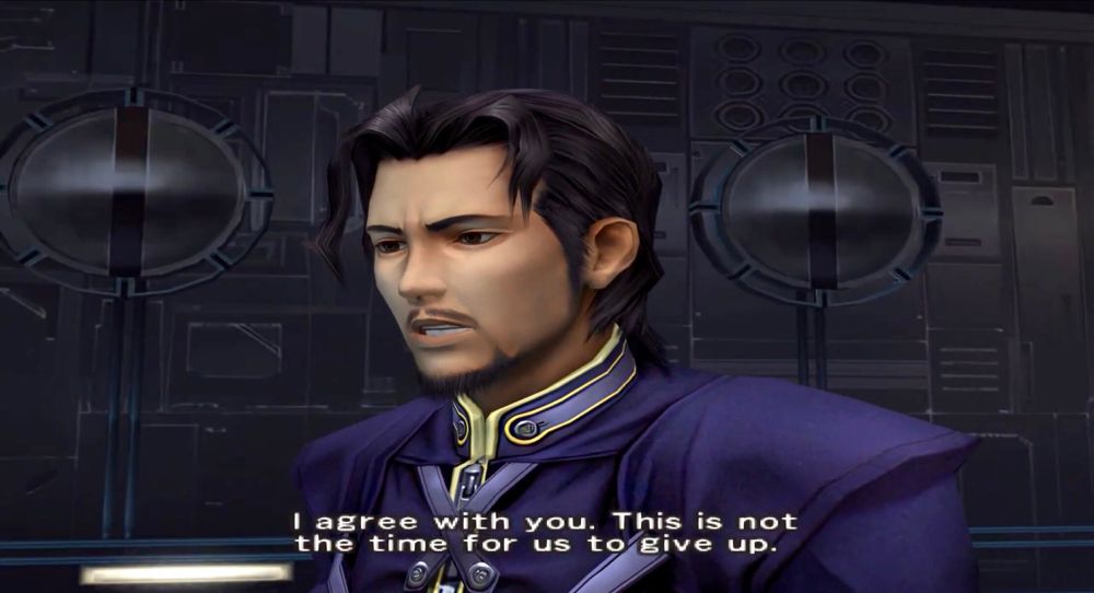 Screencap from Dirge of Cerberus. Reeve Tuesti looks at Vincent Valentine (offscreen) and says, “I agree with you. This is not the time for us to give up.” He’s echoing Vincent’s previous words of encouragement to him, and looks very serious as he says it. 