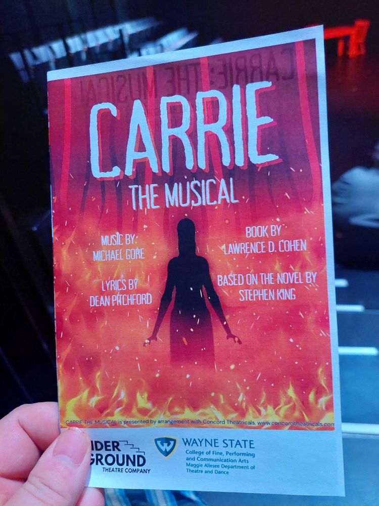 Program for Carrie: The Musical at Wayne State Universit. The silhouette of a teenage girl surrounded by flames. 