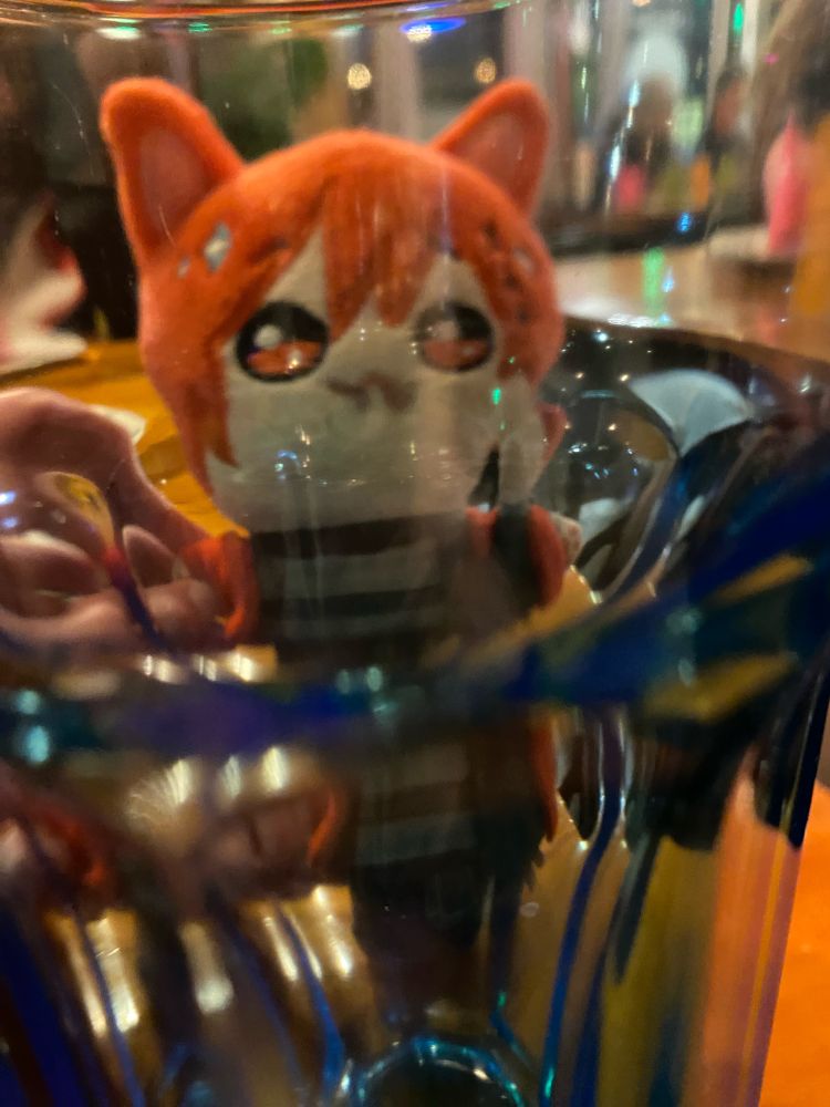Graha plushie peering through a glass