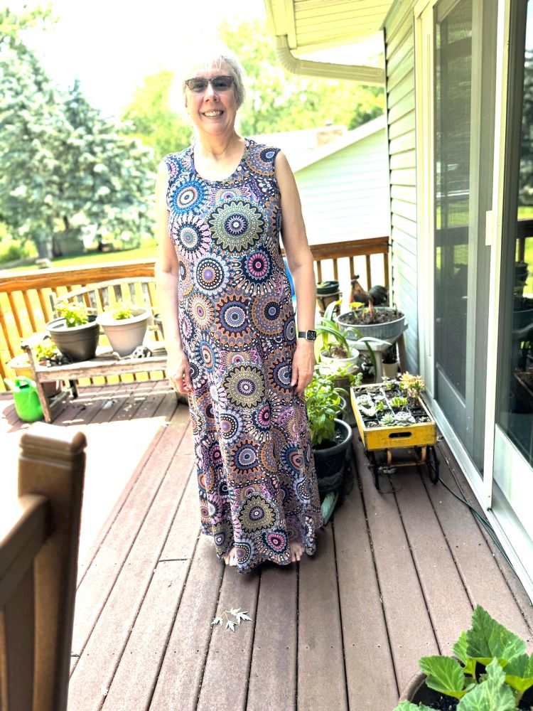 Woman on a summer day, wearing a wild patterned maxi dress. 