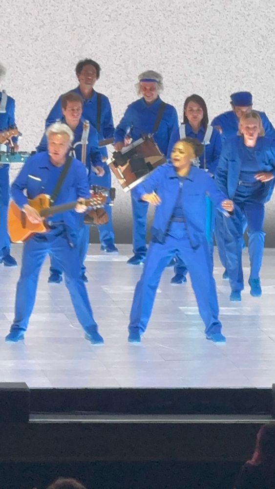 David Byrne and backup singers dancing on stage 