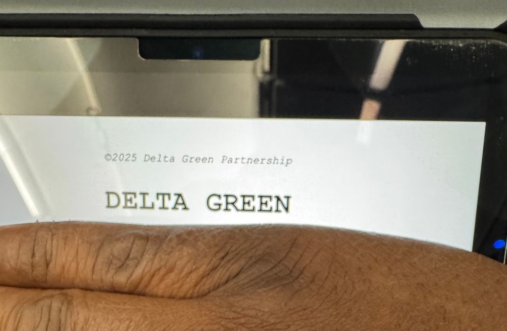 Chris’s hand covering a delta green manuscript 