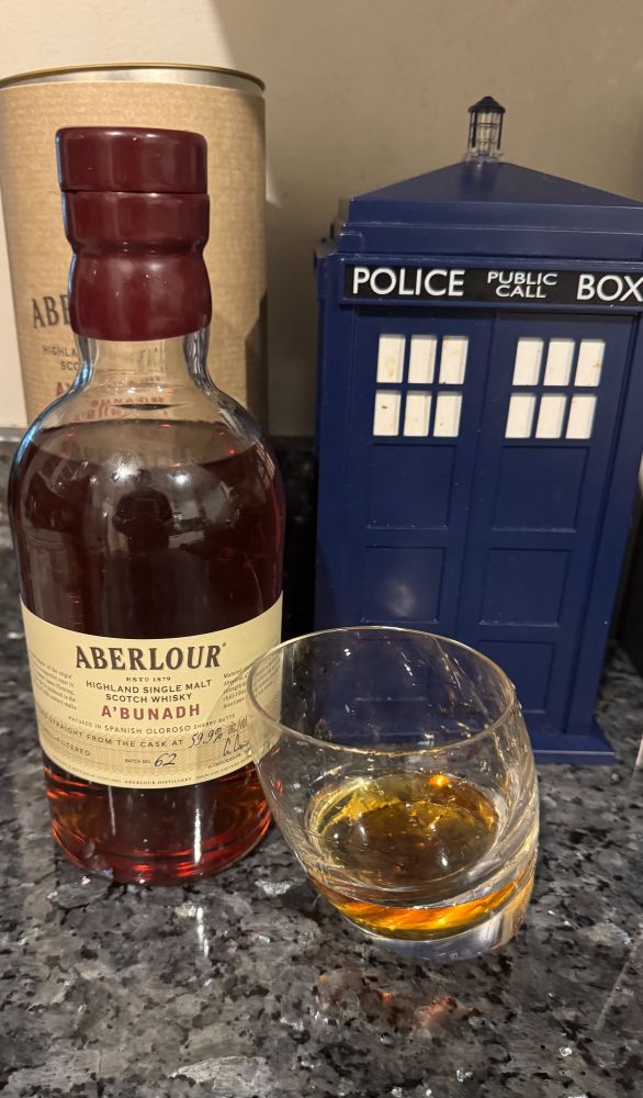 Aberlour Highland Single Malt Scotch Whiskey bottle with a glassing having a two-finger pour in front of a Tardis
