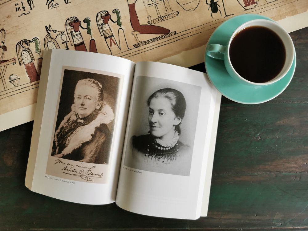 Porträt von Amelia Edwards auf einem Tisch neben einem Blatt mit Hieroglyphen.