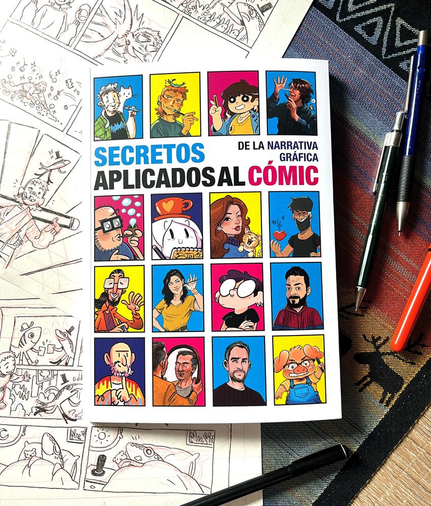 Foto de la portada del libro Secretos de la narrativa gráfica aplicados al cómic, en la que salen una serie de viñetas con retratos de les autores participantes. Alrededor del libro, dos páginas a lápiz, y unos cuantos bolígrafos.