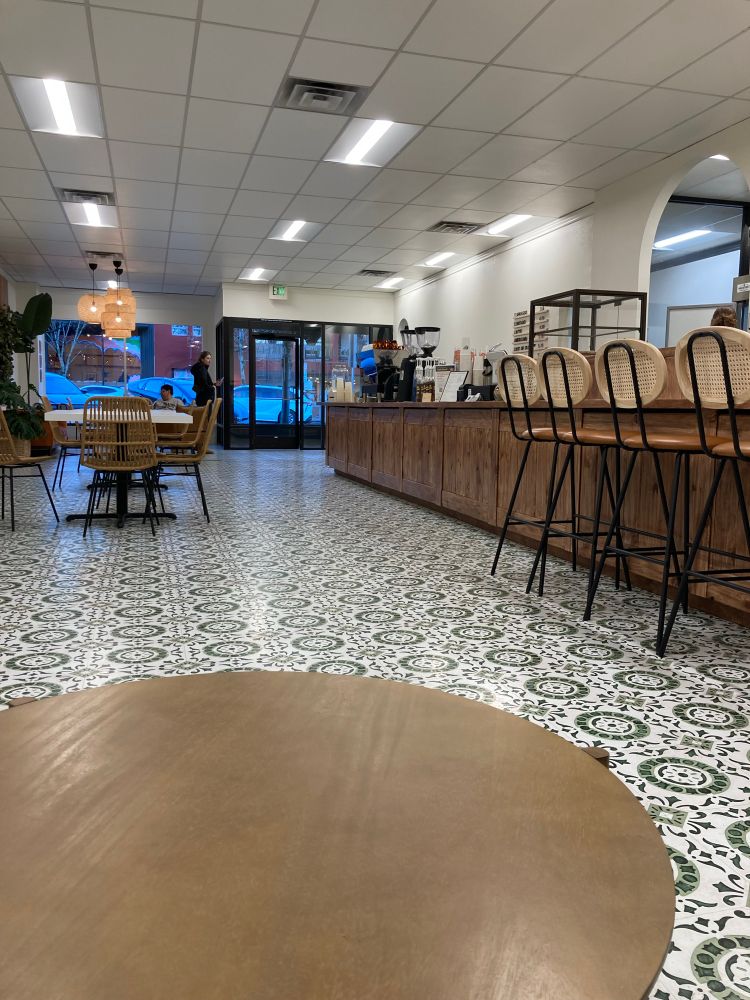 Gorgeous Mexican coffee shop interior with green tiled floor and long wood bar 