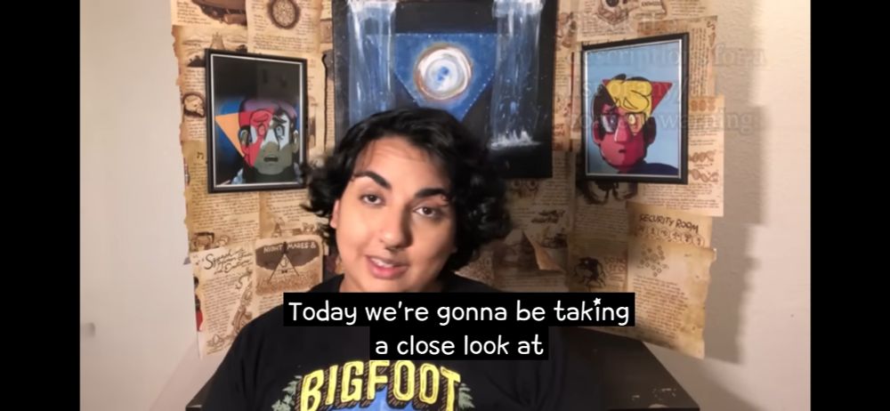 YouTuber Hena Hyperfixates in front of a display board of images and book pages from the show Gravity Falls. Subtitles read "Today we're going to be taking a close look at" 