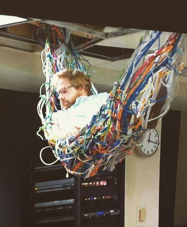 a man sleeping, suspended in a hammock of cables